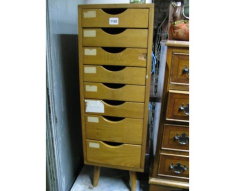 A small medium to light oak freestanding pedestal flight of eight filing drawers raised on simple splayed supports, 84 cm hig