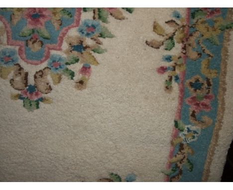 An Indian wool carpet with deep pile and white ground field set within pale blue and pastel shaded floral borders, 240cm x 13