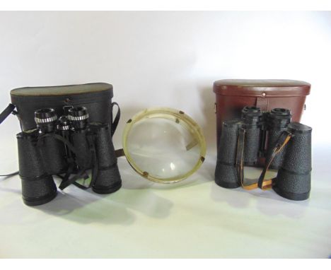 Two pairs of vintage binoculars together with a glass lens 18cm diameter