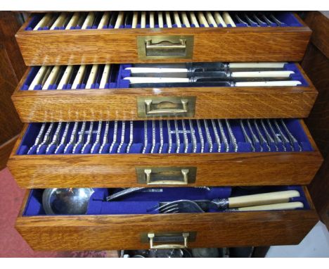 A substantial early 20th century oak canteen with flush brass carrying handles and with pair of doors enclosing four drawers 