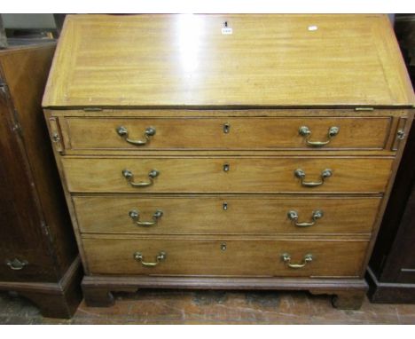 A Georgian mahogany bureau of four long drawers, the fall flap enclosing a fitted interior of drawers, pigeon holes and centr
