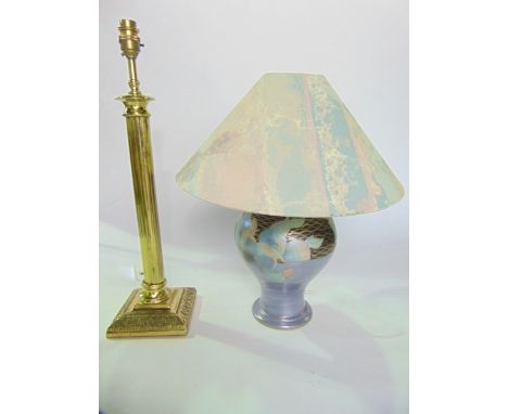 A brass table lamp with reeded column detail raised on a cast base, together with a further ceramic table lamp with incised d