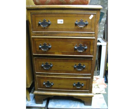 A small reproduction yew wood veneered four drawer bedside chest in the Georgian style raised on bracket shaped supports, 45 