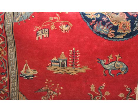 A large Persian style carpet with red ground and central medallion upon a blue field with character animal and floral detail 