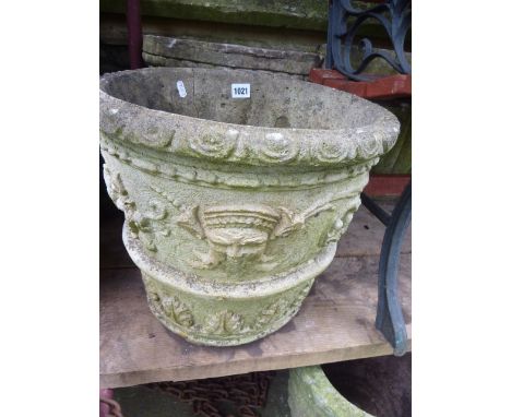 A pair of weathered cast composition stone planters of circular tapered form with aztec type relief detail and traces of pain