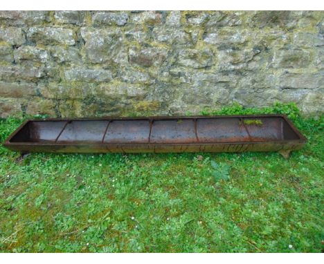 A vintage cast iron pig feeding trough of rectangular form with 5 rung divisions, 6ft long approx