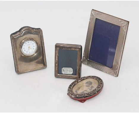 A modern silver clad easel clock with a quartz movement, H9cm, together with 3 silver clad easel photo frames (4)