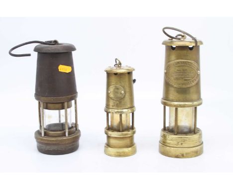 A brass miner's lamp, bearing a label for The British Coal Mining Company, Wales, UK, height 22cm, together with two others