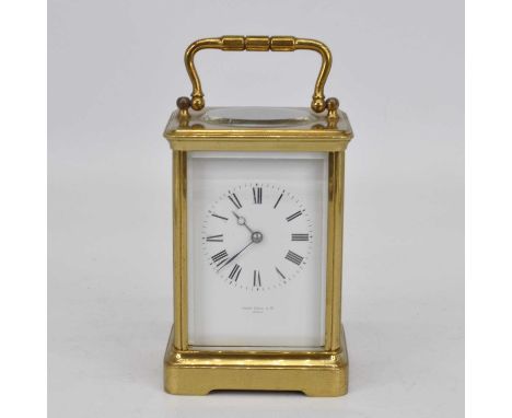 An early 20th century brass cased carriage clock, the enamel dial showing Roman numerals, signed John Hall &amp; Co., Paris, 