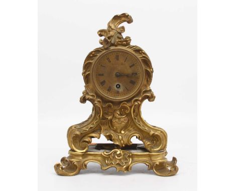 A 19th century French Rococo revival gilt brass mantel clock, the engine turned decorated dial showing Roman numerals and sig