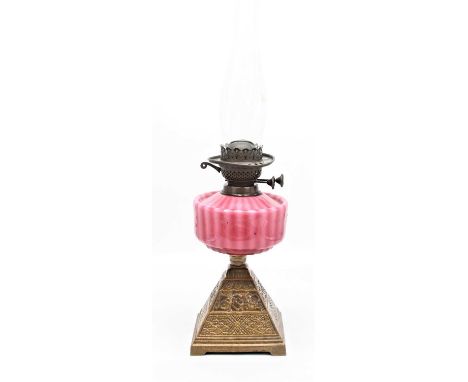 A late 19th century brass oil lamp, having a red glazed font and moulded base, height 57cm