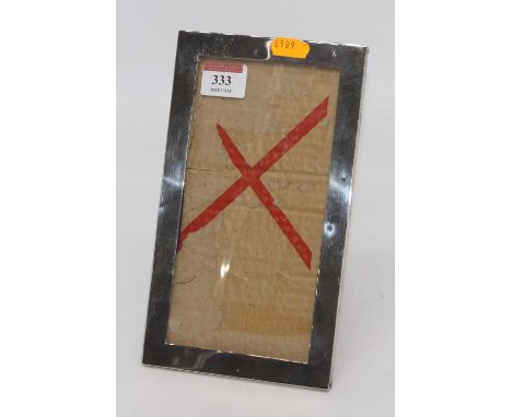 An Edwardian silver clad easel photo frame of plain rectangular form, 23x13cm (a/f)Poor condition.The silver is dented and sc