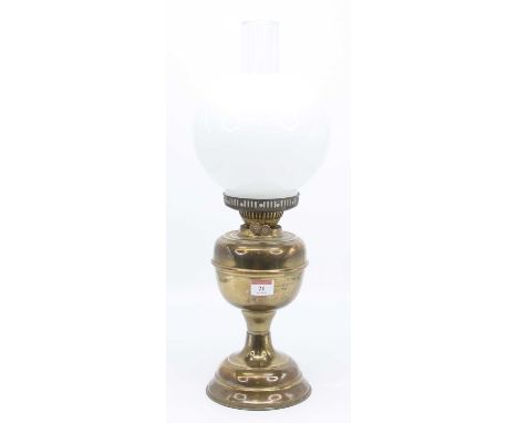 A Victorian brass oil lamp, the milk glass shade above a brass font, height 52cm