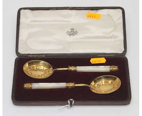 A pair of presentation spoons each having a gilt wash oval bowl repousse decorated with a band of flowers and a mother of pea