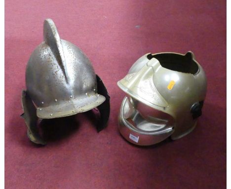 A reproduction metal knights helmet, together with an ice bucket in the form of a helmet