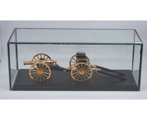 A lacquered brass scale model of a Napoleonic cannon and carriage, mounted on an ebonised plinth under a glass case, w. 58, d