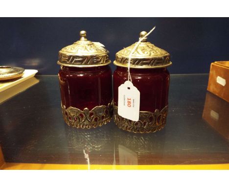 A pair of white metal and ruby glass lidded pots