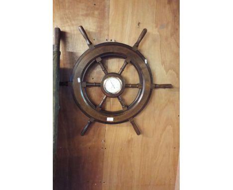 An ornamental ship's wheel with thermometer inset
