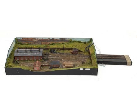 '00' gauge - table top model railway layout with multiple tracks around a central engine shed with other buildings and figure