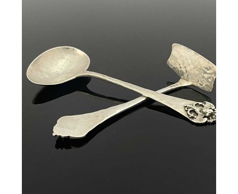 Sibyl Dunlop, an Arts and Crafts silver spoon and pusher, London 1923, planished form, the terminals applied with cast winged
