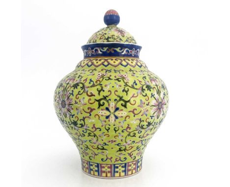 A Chinese porcelain lime green lidded vase, 19th Century, of baluster form, intricately decorated with auspicious emblems in 