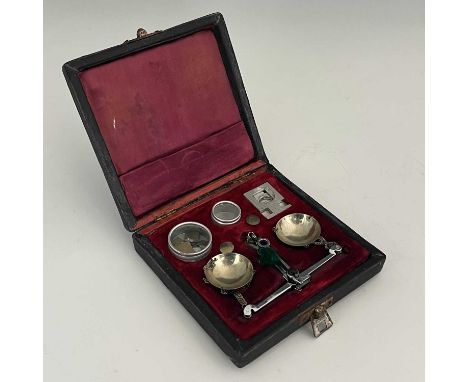 An antique Chinese set of weighing scales, with weights and added accessories in a fitted leather bound box with red vellum i