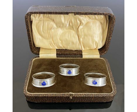 Charles Horner, three Arts and Crafts silver and enamelled napkin rings, Chester 1917 and 1923, circular form with applied bl