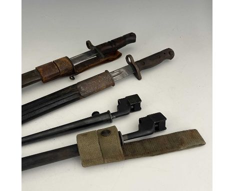 Four British bayonets, including a 1907 pattern SMLE sword bayonet by Remington, two piece wooden grip housed in leather moun