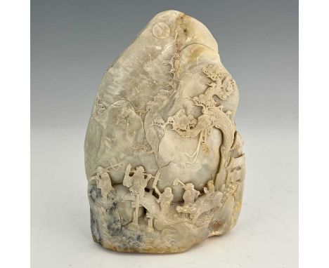 A Chinese soapstone mountain boulder carving, the naturalistic rock carved in the round with an extensive landscape of figure