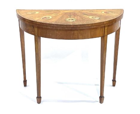A satinwood games table, 19th Century, of Sheraton design, sunburst veneered demi-lune fold-over top painted with pearl borde