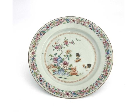A Chinese famille rose plate, 18th century, probably Qianlong, painted with cockerels, prunus and zigzag fence, within a flor