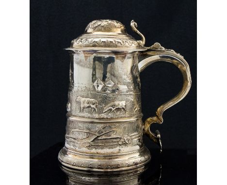 A George II silver lidded tankard, cylindrical form with domed lid and cast foliate thumb piece, embossed and chased with rur