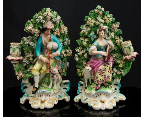 A pair of Derby patch mark figural candlesticks, circa 1760-65, modelled as shepherd and shepherdess musicians before boccage