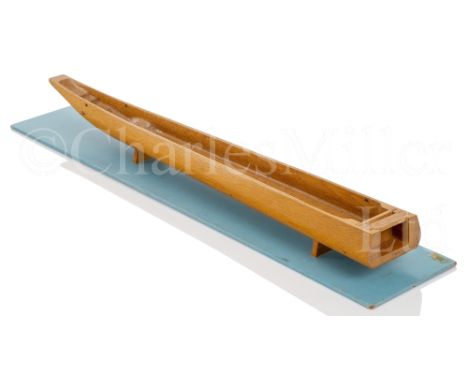 A 1970S SCALE MODEL FOR A DUG-OUT CANOE the 33in. hull carved from the solid with sliding panels to stern, mounted on blue di