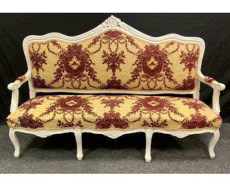 A Victorian painted three-seat salon sofa, shaped and carved cresting rail, stuffed over upholstery, 178cm wide, 113cm high. 