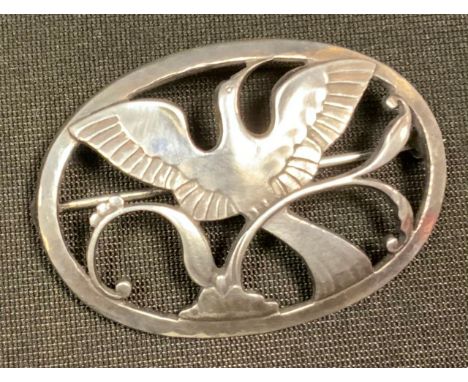 Arno Malinowski for Georg Jensen, a Danish silver oval panel brooch, oval ring enclosing a bird in flight, beads and foliage,