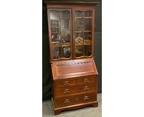 An Art Nouveau mahogany bureau bookcase, outswept cornice above a pair of glazed doors, fall front enclosing a fitted interio