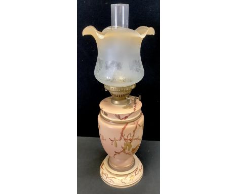 A late 19th/early 20th century oil lamp, etched glass shade, vaularbody decorated with flowering branches on a buff ground. 5