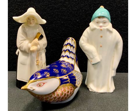 A Royal Worcester candle snuffer as a Nun; another, child in large winter coat, black, back stamp; a Royal Crown Derby paperw