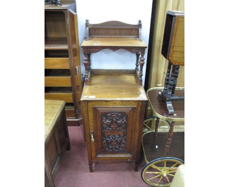 A Late XIX Century oak cabinet with a shaped back, single shelf supported by turned supports, base with a carved panel on sma