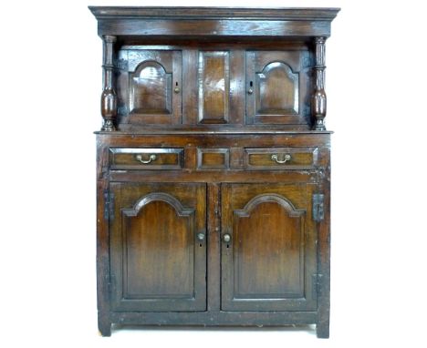 An 18th century oak court cupboard, the cornice supported on two baluster columns, two small arched fielded panel doors with 