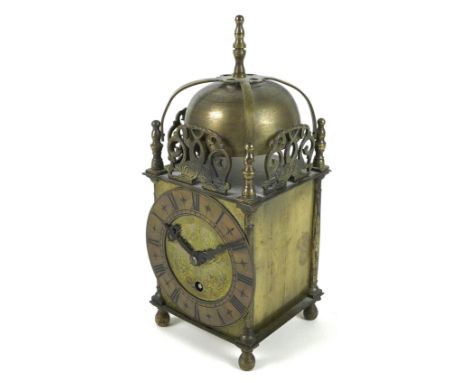 A brass cased lantern clock, in the 17th century style, with strapwork bell top within pierced spandrels modelled as dolphin 