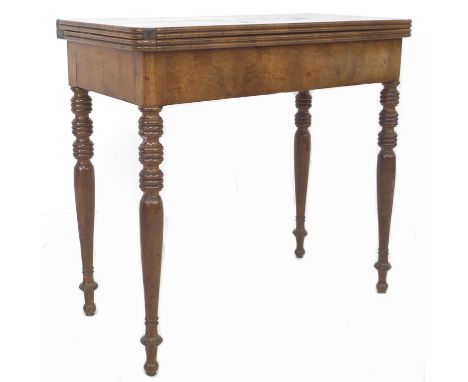 A Regency mahogany card table, fold over surface with green fabric surface with printed pattern, raised on turned legs, 81.5 