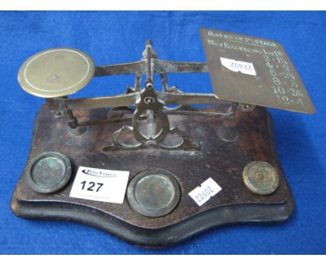 Small set of brass postal scales with weights on wooden serpentine base. 