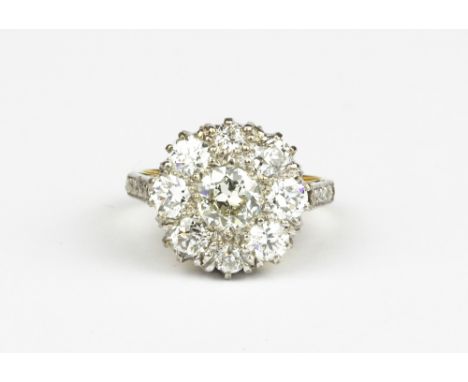 An 18ct yellow and white gold (stamped 18ct) cluster ring set with brilliant cut diamonds, approx. 1ct centre diamond, approx