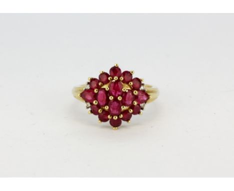 A 9ct yellow gold (stamped 9k) ruby and diamond set cluster ring, (L.5).