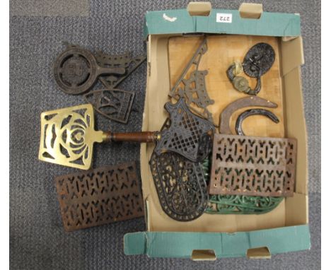 A painted Victorian brass lion head door knocker with a group of antique cast iron and brass trivets etc.