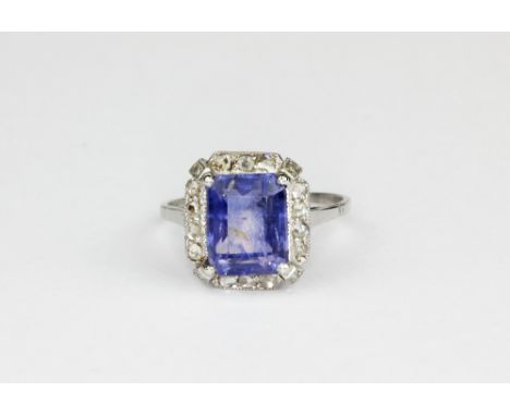 A white gold (tested high carat gold) ring set with a baguette cut sapphire surrounded by rose cut diamonds, (O.5).