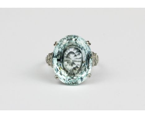 A white metal (tested high carat gold) ring set with a large oval cut aquamarine and diamond set shoulders, approx. 13ct cent