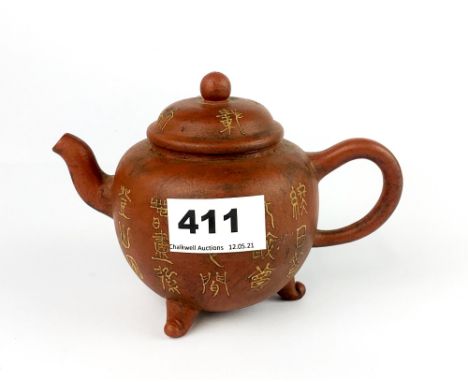 A Yixing terracotta teapot slip decorated with archaic characters, H. 11cm. Spout to handle 16cm.